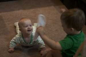 Brenden is shaking a paper plate in her face and she is laughing like crazy.