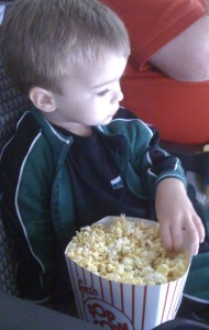 Kicking back with his popcorn snack and a little hockey.